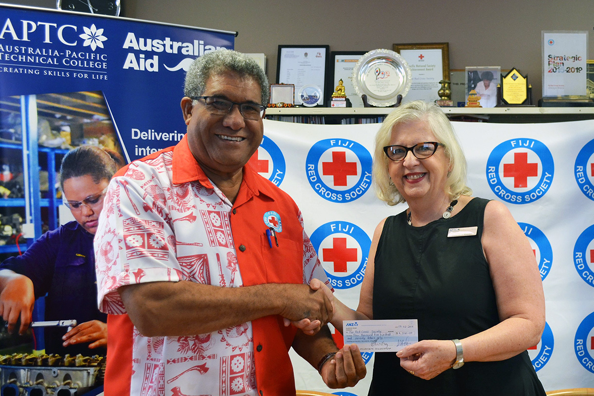 FRCS Director General, Mr Filipe Nainoca receives cheque from APTC Executive Director - SME, Ms Carol-Anne Blecich