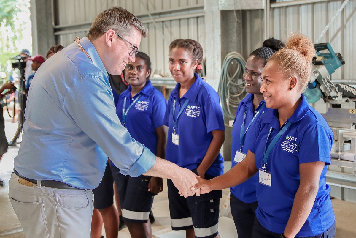 Hon. Pat Conroy shares a light moment with a group of female students from the Construction course at the APTC Campus.